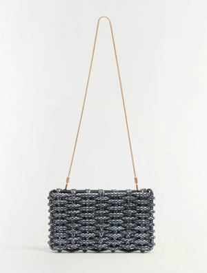 The Simkhai Morgan Clutch is a rectangular woven black and silver handbag featuring a thin, long gold shoulder strap, displayed against a plain white background.