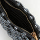 Close-up of an open Simkhai Morgan Clutch, featuring a beaded exterior, gold zipper, black interior, and visible card slots inside.
