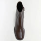 The Simkhai Bianca Stretch Leather Ankle Boot, shown in brown from a top-down view against a plain white background, features a block heel, rounded toe, and highlights its side zipper detail.