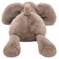 A Jellycat Smudge Elephant, Medium—crafted from soft brown fur—lies face-down with splayed ears and outstretched legs, resembling a sleepy elephant after a busy day.