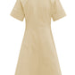 Back view of the Callas Milano Sora Dress, a knee-length, short-sleeved beige outfit made from Italian stretch poplin, featuring a sleek silhouette with cuffed sleeves, round neckline, and back zip closure.