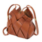 The Charlotte Crossbody by Ulla Johnson is a brown leather handbag featuring an intricate basketweave design and thin shoulder straps with gold accents.