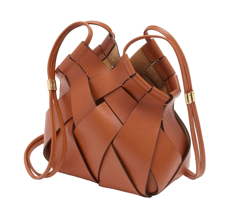 The Charlotte Crossbody by Ulla Johnson is a brown leather handbag featuring an intricate basketweave design and thin shoulder straps with gold accents.