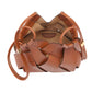 The Charlotte Crossbody by Ulla Johnson is a brown woven calfskin leather handbag with an open top, round base, and thin side strap. Artisanal craftsmanship shines in every detail; interior label reads “ILLA STEWART.”.