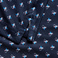 Close-up of the Johnnie-O Boys' Performance Jersey Jr. Polo in For The Birdies Print shows soft navy fabric with white and blue birds with pink beaks and feet, plus seam and folded edge details that highlight this unique polo material.