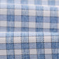 Close-up of the Boys' Performance Jr. Button Up Shirt Westwood Print by Johnnie-O, highlighting the light blue and white checkered, wrinkle-resistant fabric and its fine texture.