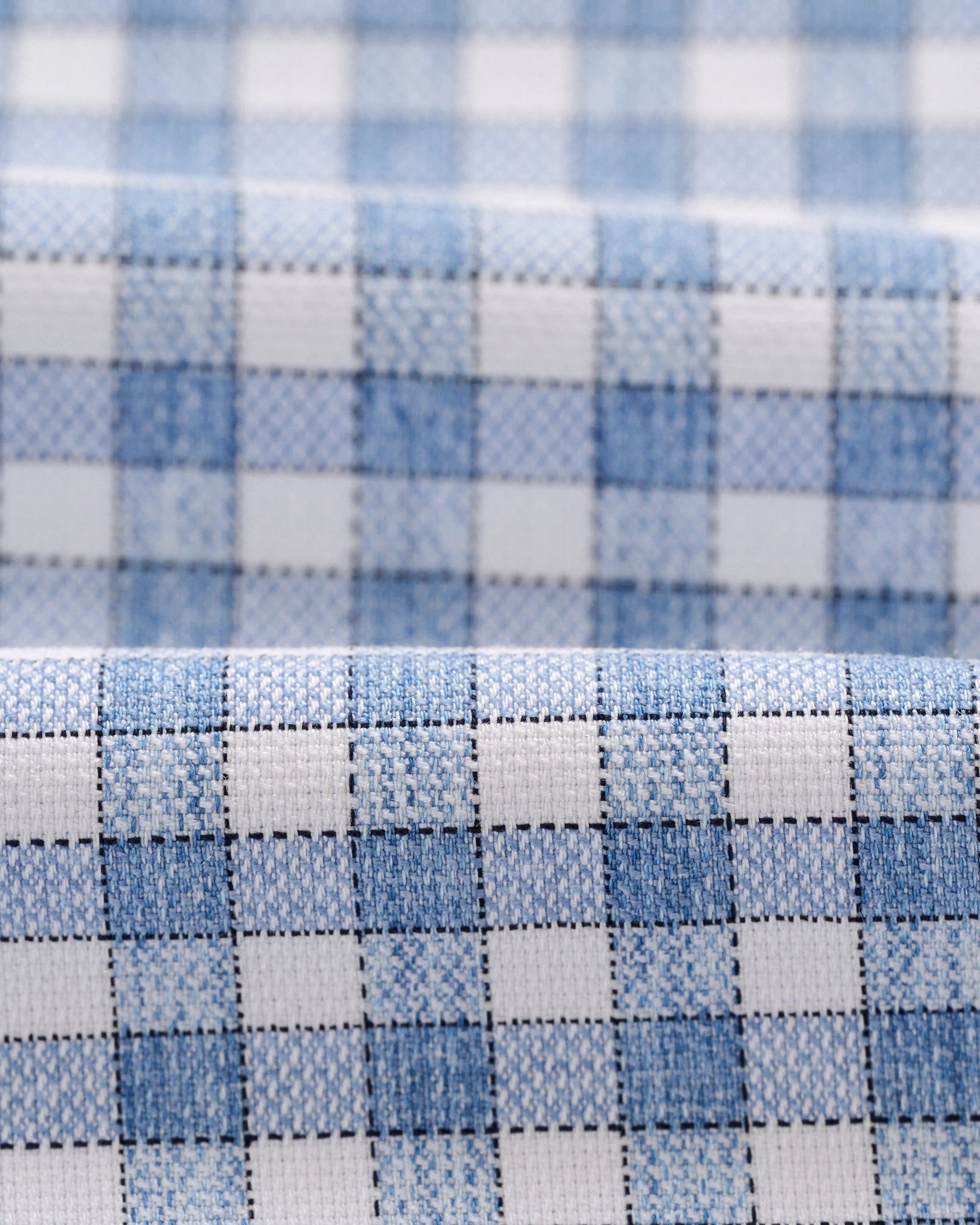 Close-up of the Boys' Performance Jr. Button Up Shirt Westwood Print by Johnnie-O, highlighting the light blue and white checkered, wrinkle-resistant fabric and its fine texture.