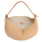 The Fortuna Raffia Bag by Mansur Gavriel is a beige woven handbag made from soft Italian raffia. It features a light brown leather handle, an open top, and a simple fabric interior.