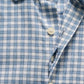 Close-up of the Johnnie-O Westwood Button Down, a blue and white checkered performance dress shirt featuring white buttons, a classic collar, and detailed fabric texture and pattern.