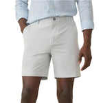 A person in a light blue shirt and tailored Faherty All Day Short 2.0, 7", with hands in pockets, stands against a plain background.