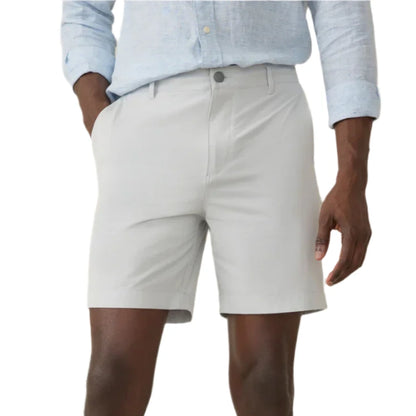 A person in a light blue shirt and tailored Faherty All Day Short 2.0, 7", with hands in pockets, stands against a plain background.