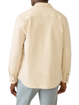 A person shown from the back wears the Faherty Sunwashed Canvas CPO in light beige and light gray pants.
