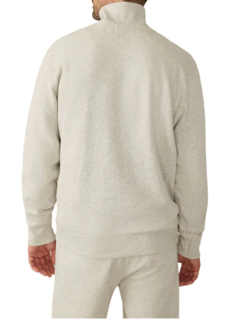 A person is wearing Faherty's High Standard Fleece Quarter Zip in light gray, seen from the back. The timeless style features a heavyweight organic cotton jacket with a high collar and matching pants.