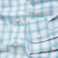Close-up of The Movement Shirt by Faherty, showcasing a light blue and white plaid design with white buttons and neatly folded cuffs, crafted from soft Supima Cotton.