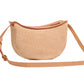 The Mansur Gavriel Moon Sling Raffia Bag features a curved shape with tan leather trim and an adjustable crossbody strap.