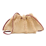 The Adria Small Crossbody by Ulla Johnson is a woven beige straw raffia handbag with frayed edges, brown leather straps, and a removable shoulder strap, shown on a white background.