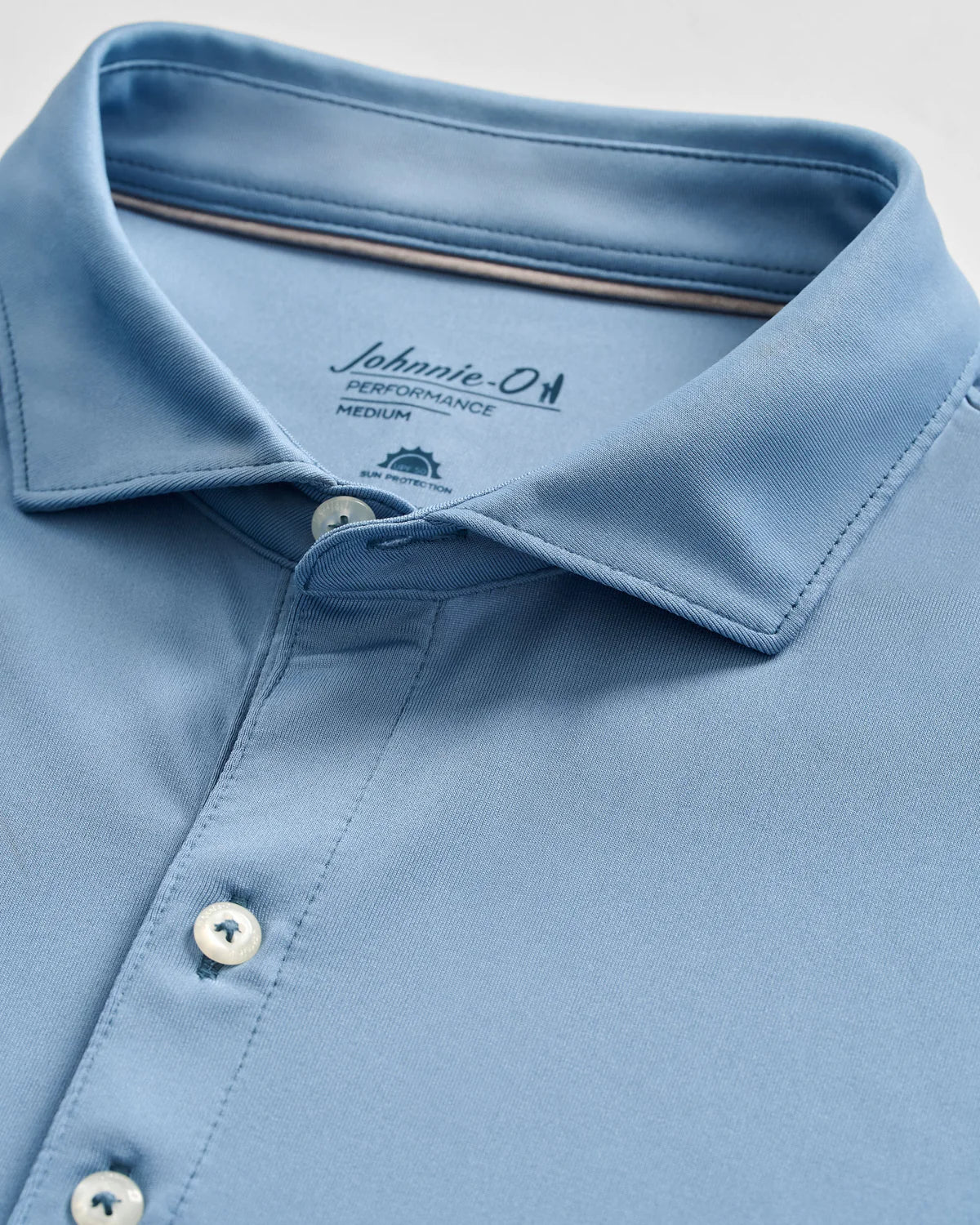 Light blue Johnnie-O Birdie Polo in size medium, shown folded with three buttons fastened and collar neatly arranged. Crafted from lightweight, moisture-wicking fabric with UPF 50 protection for all-day comfort and style.