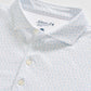 Close-up of a white Johnnie-O Marina Polo with a light blue small pattern and buttons, made from moisture-wicking fabric and featuring the brand label inside the collar.