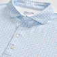 Johnnie-O Minty Polo: A light blue short-sleeve men's performance polo shirt featuring a subtle pattern of blue and orange illustrated sea creatures, partial button placket, and a visible Johnnie-O brand label inside the collar.