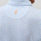 Close-up of the back of a man's neck and shoulders, featuring the Johnnie-O Minty Polo in a light blue pattern with a small embroidered orange surfboard below the collar.