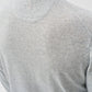 Close-up of a person's back wearing the Johnnie-O Albus Crew, a light gray, speckled knit ultrasoft crewneck sweater featuring a visible seam detail near the neckline—perfect for everyday layering.
