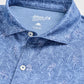 Close-up of the Johnnie-O Osmond Polo, a blue collared shirt adorned with a white tropical leaf and flamingo pattern. Crafted from lightweight, moisture-wicking fabric for all-day comfort, this polo features button details and a “johnnie-O Performance Medium” tag. With UPF 50 protection, the Osmond Polo is an ideal choice for sunny days.
