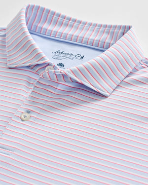 A close-up of the Johnnie-O Rez Polo, a light blue men's polo shirt featuring thin red and white horizontal stripes and white buttons. This moisture-wicking polo provides UPF 50 sun protection for all-day comfort.