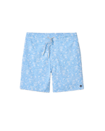 The Johnnie-O Swingin Swim Trunks, featuring a light blue fabric with a playful white floral print, white drawstring, and a small round black and white logo patch on the lower left leg, are stylish surf shorts shown on a white background.