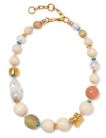 The Lizzie Fortunato Andros Necklace, by brand Lizzie Fortunato, showcases a captivating collection of beads in gold, white, turquoise, and coral tones. It is beautifully accented with peach calcite and freshwater pearls, all elegantly connected with a gold clasp.