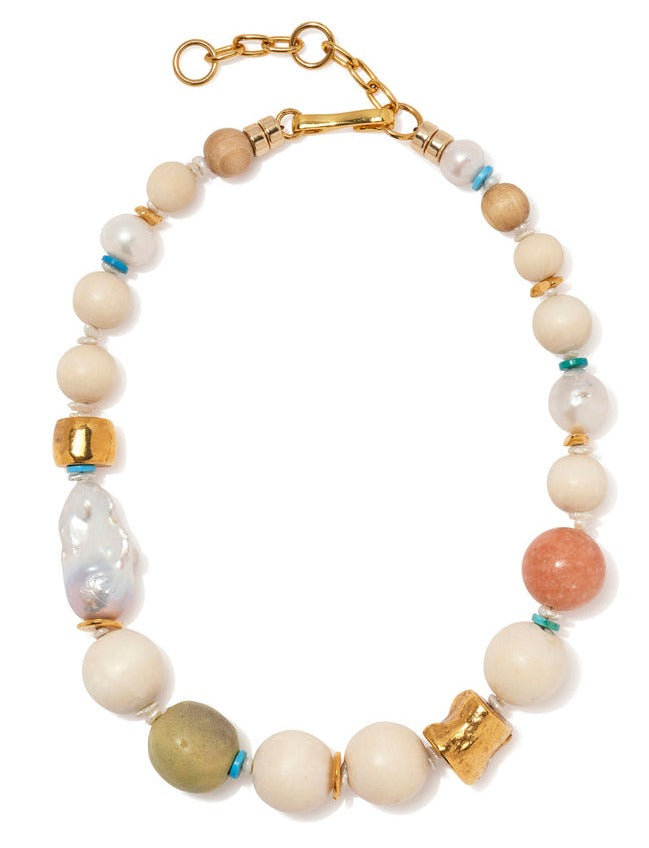 The Lizzie Fortunato Andros Necklace, by brand Lizzie Fortunato, showcases a captivating collection of beads in gold, white, turquoise, and coral tones. It is beautifully accented with peach calcite and freshwater pearls, all elegantly connected with a gold clasp.