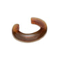 The Ridge Cuff by Lizzie Fortunato is a brown, translucent resin bracelet with a thick, open-ended design—ideal for stacking and bold style.