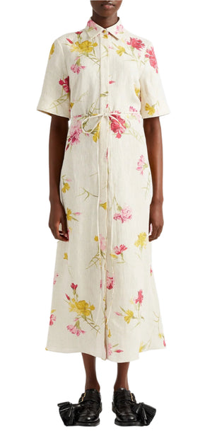 Someone in an Erdem Short Sleeve Linen Shirt Dress with a floral design and tie-fastening belt, complemented by black shoes.