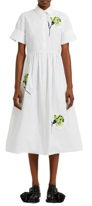 Someone is wearing an Erdem Short Sleeve Embroidered Shirt Dress, featuring a white design with embroidered carnations, paired with black strappy shoes.