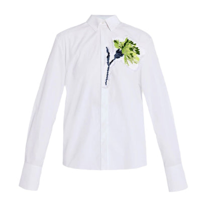 The Erdem Long Sleeve Embroidered Shirt is an oversized white cotton poplin piece adorned with green and blue floral embroidery on the upper left side.