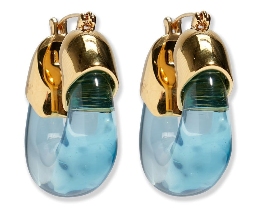 The Organic Gold Hoops by Lizzie Fortunato feature gold-toned metal tops and curved, translucent blue resin drops.