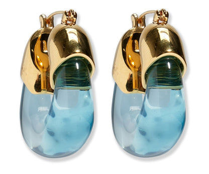 The Organic Gold Hoops by Lizzie Fortunato feature gold-toned metal tops and curved, translucent blue resin drops.
