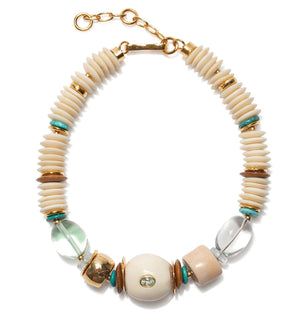 The Coquina Necklace by Lizzie Fortunato features cream, gold, turquoise, and clear beads in assorted shapes, recycled bone accents, a gold clasp, and an adjustable chain.