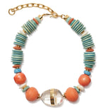 The Neptune Collar by Lizzie Fortunato is a stunning statement necklace with turquoise and coral discs, round peach beads, a clear oval bead with gold bands, and a gold chain clasp—perfect for any occasion.