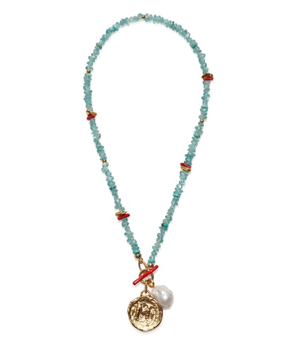 The Crystal Cala Necklace by Lizzie Fortunato features turquoise beads, red accents, blue apatite beads, a gold coin pendant, and a freshwater pearl charm.