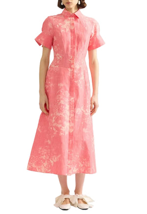 A person wearing the Erdem Rose Bouquet Linen Chine Midi Shirt Dress in rose-pink, styled with flat, bow-accented shoes.