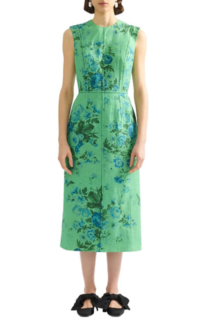 A woman wears the Erdem Rose Bouquet Linen Pencil Midi Dress and black flat shoes with large bows, standing against a white background.