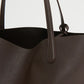 Close-up of the Mansur Gavriel Everyday Soft Tote, crafted from dark brown Italian calf leather with two handles, highlighting its textured material and minimalist design.