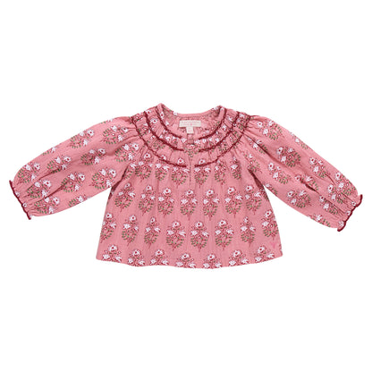 The Girls' Ava Top by Pink Chicken, shown in Pink Strawflower with a floral block print, ruffled collar, and gathered cuffs, is displayed on a white background.