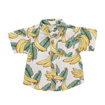 The Pink Chicken Baby Boys’ Jack Shirt is a lightweight, breathable short-sleeve button-up tailored cotton shirt featuring a cheerful yellow banana and green leaf print on a white background, with a chest pocket for added style and convenience. Designed for all-day comfort, it’s perfect for baby boys.