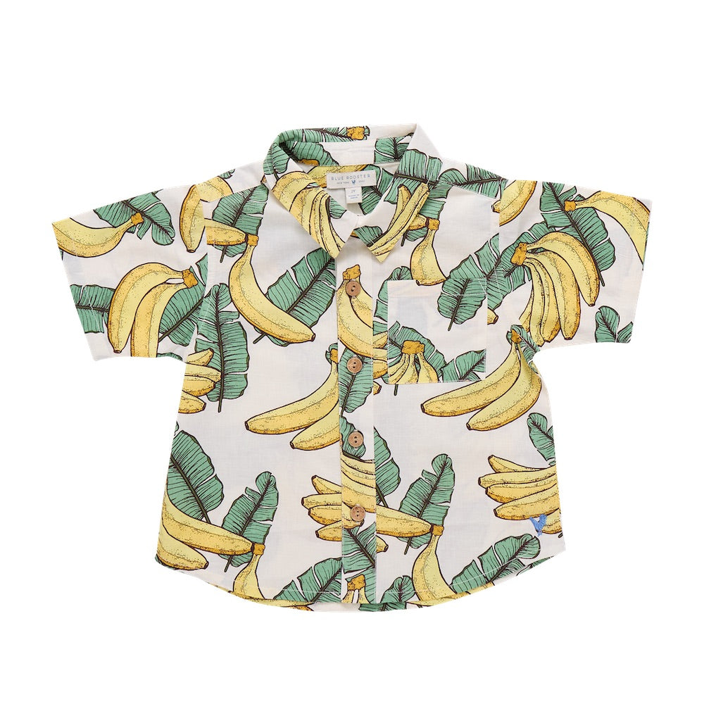 The Pink Chicken Baby Boys’ Jack Shirt is a lightweight, breathable short-sleeve button-up tailored cotton shirt featuring a cheerful yellow banana and green leaf print on a white background, with a chest pocket for added style and convenience. Designed for all-day comfort, it’s perfect for baby boys.
