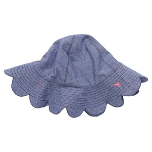 The Pink Chicken Baby Scallop Sun Hat is a blue chambray sun hat with a scalloped brim and a small pink embroidered detail on the side, shown on a white background.