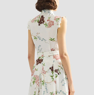 A woman is seen from the back wearing the Erdem French Chintz Cotton Sleeveless Shirt, featuring a white floral design, against a plain light grey background.