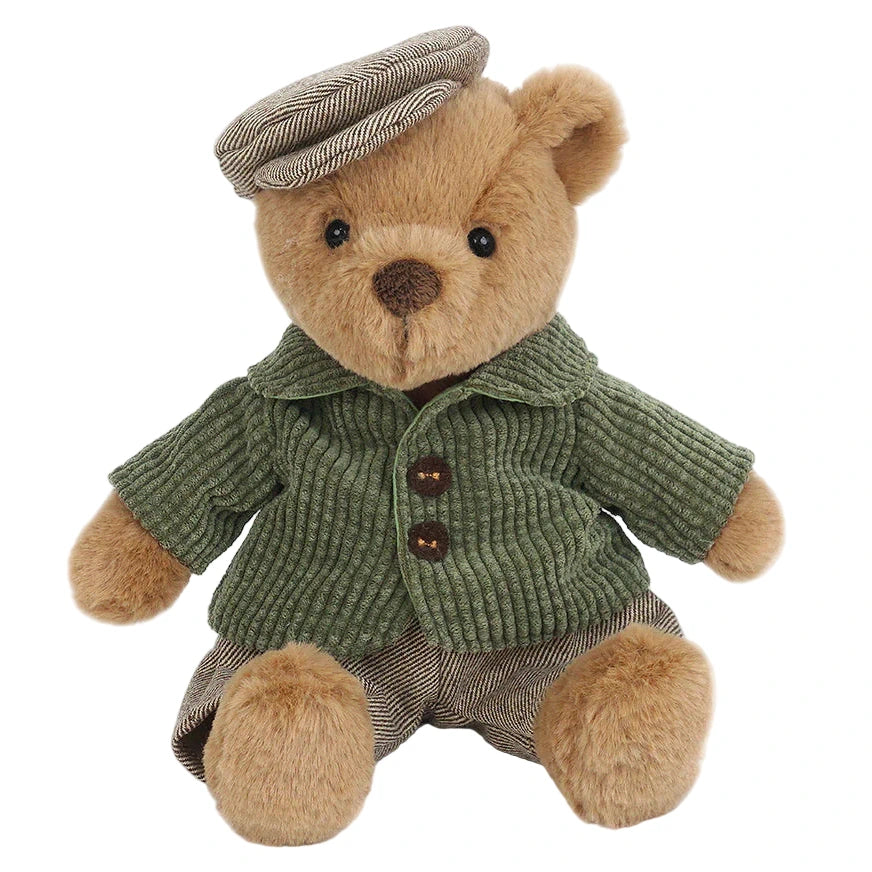 Bernard Bear by Mon Ami sits upright against a white background, dressed in a green corduroy jacket, brown striped pants, and a matching flat cap.