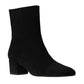 The Aimee Short Boot by Staud is a black suede ankle bootie with a mid-height block heel and pointed toe, featuring a convenient side zipper, shown against a white background.