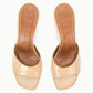 A pair of beige, open-toe Bea Mule heeled sandals by Staud, featuring a square toe and "STAUD" embossed on the brown insoles.